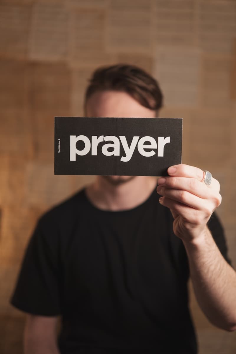 A man holding up a sign that says prayer